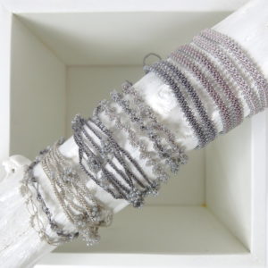 Gedrehtes Häkel-Armband mit grau-silber schimmernden Glasperlen
