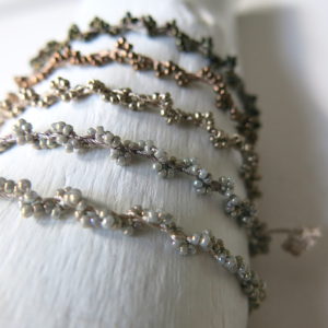 Gedrehtes Häkel-Armband mit metallic schimmernden Glasperlen
